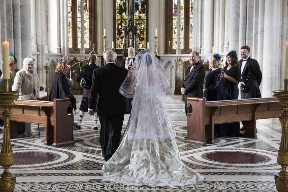 bride walks down the aisle of the marble chapel of Mount Stuart