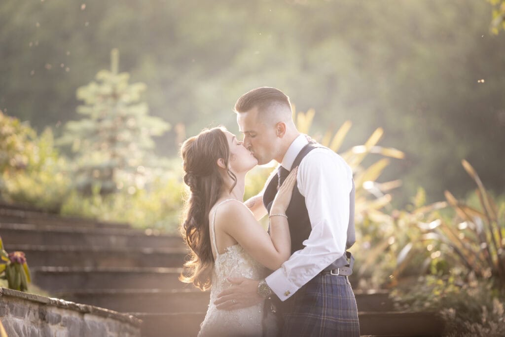 bride and groom share a kiss during Golden hour at Loch Lomond