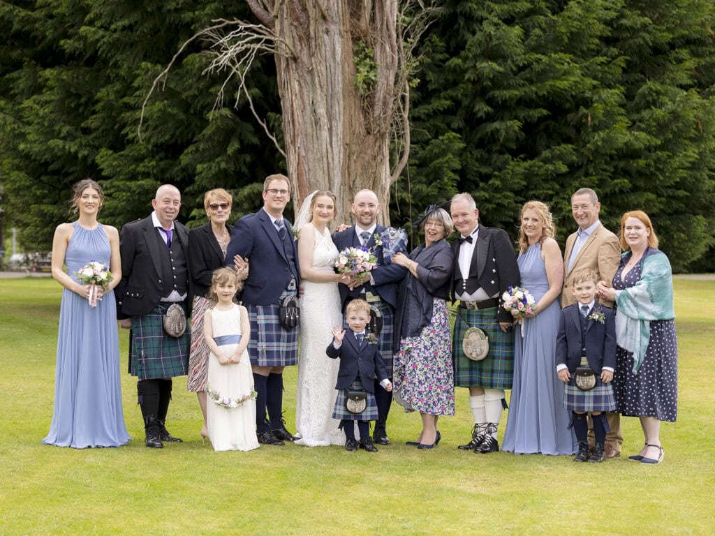 Bride and groom with family and bridal party in formal wedding group photo