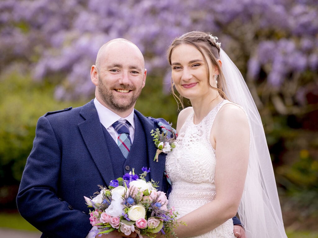 Bride and groom standing with guests outside The Cruin wedding venue on Loch Lomond