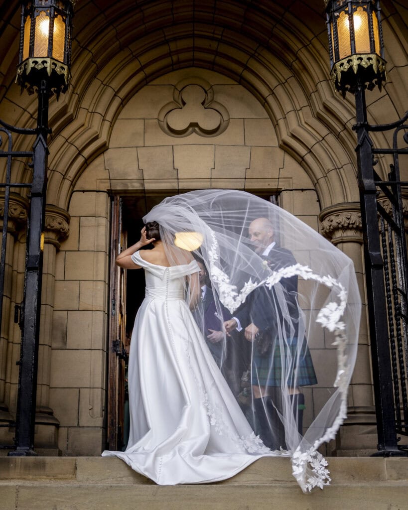 Bride’s veil blowing in the wind outside Glasgow University Chapel